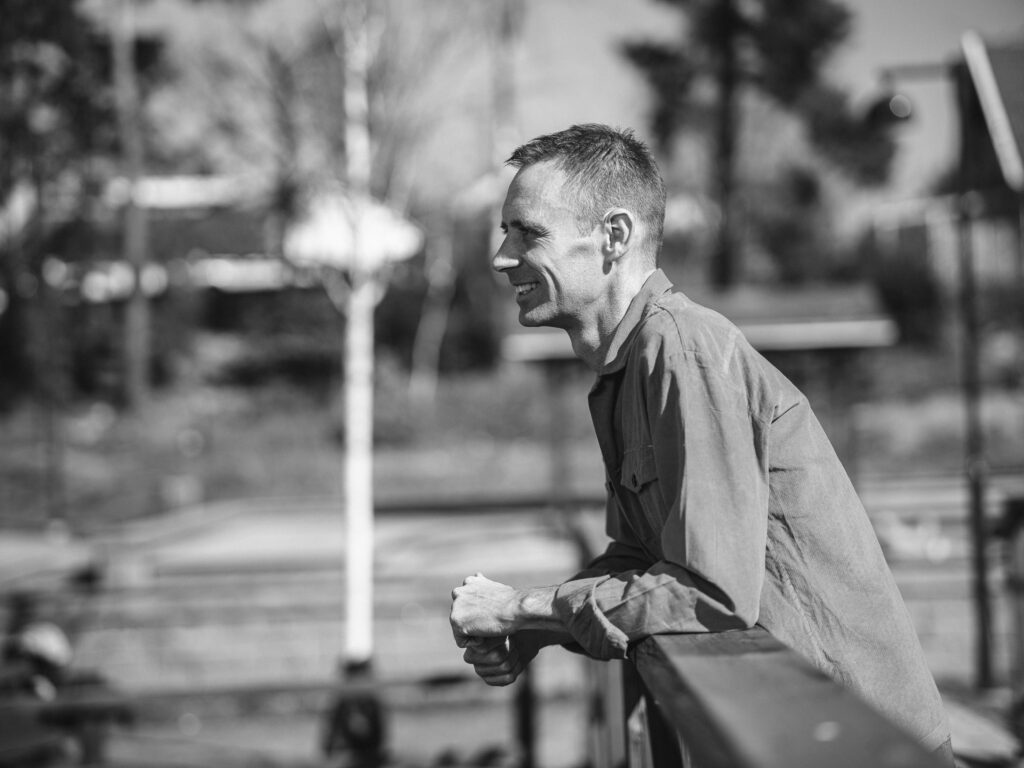 Fredrik Bauer reflekterande ståendes på bro på svartvitt foto
